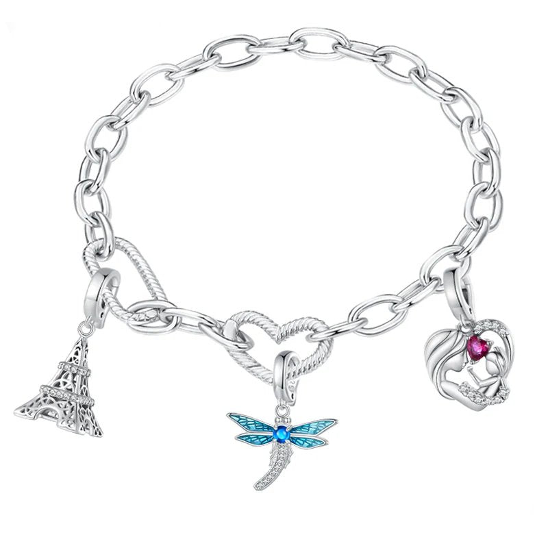 Silver charm bracelet with Eiffel Tower, dragonfly, and mother-child charms on a white background.