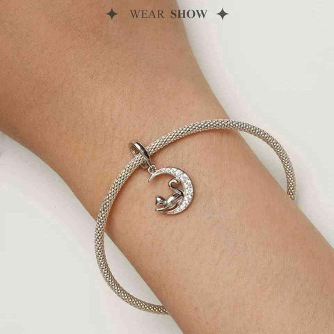 Silver mesh bracelet with a cat on crescent moon charm, worn by a model, highlighting the detailed craftsmanship.