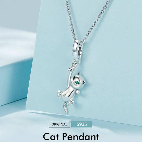 Sterling Silver Hanging Cat Charm with Emerald Eyes - Sterling silver cat pendant necklace with emerald eyes displayed on a light blue background.