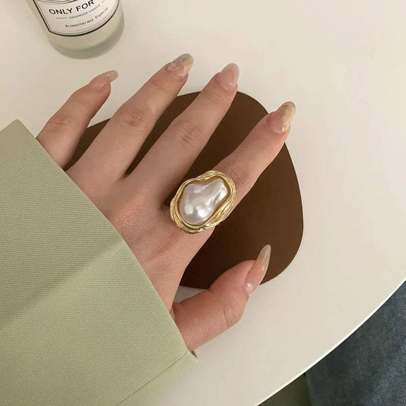 Adjustable Gold Ring with Unique Baroque Pearl - Elegant gold ring with a unique baroque pearl centerpiece, styled on a woman's hand, highlighting its luxurious and sophisticated design.