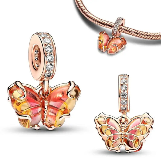 Sterling silver butterfly charm with orange and pink enamel wings and sparkling crystal accents, symbolizing transformation and beauty.