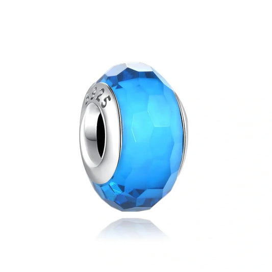 Sterling silver charm with faceted blue crystal for a vibrant and elegant look.