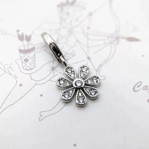 Silver flower charm with clear stones.
