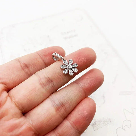 Silver flower charm with crystals.