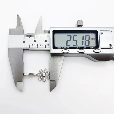 Flower-shaped pendant being measured.