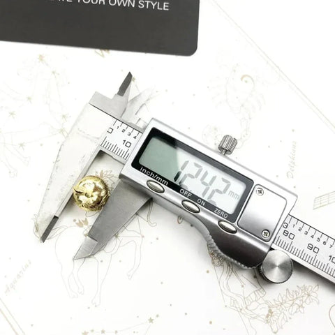 Digital caliper measuring a gold bead.