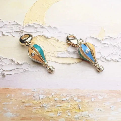 Two gold-trimmed hot air balloon charms.