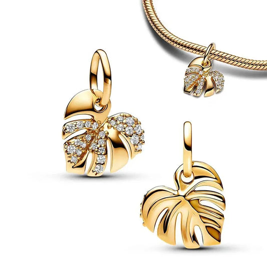 Golden monstera leaf charm featuring crystal accents, capturing the natural beauty of tropical plants, ideal for nature lovers.