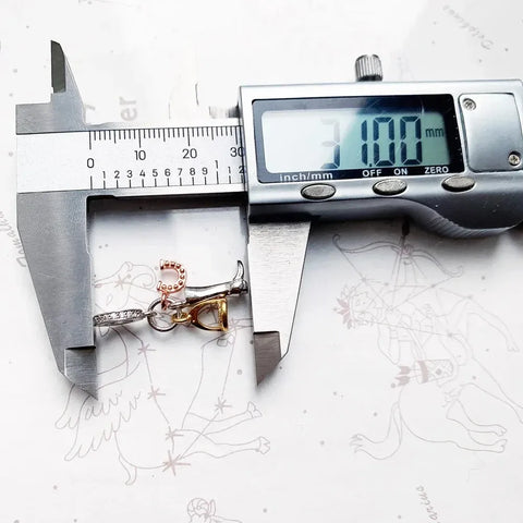 Jewelry charm being measured.