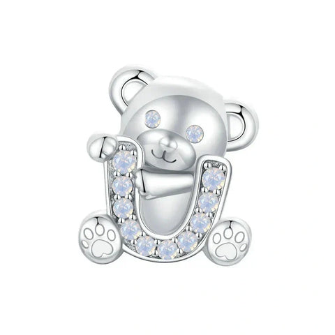 Silver teddy bear charm with gemstone horseshoe.