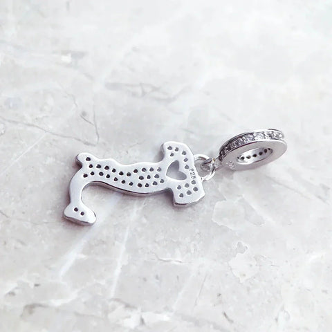 Silver dachshund charm with embedded crystals.