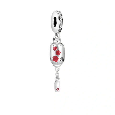 Silver charm with red floral accents.