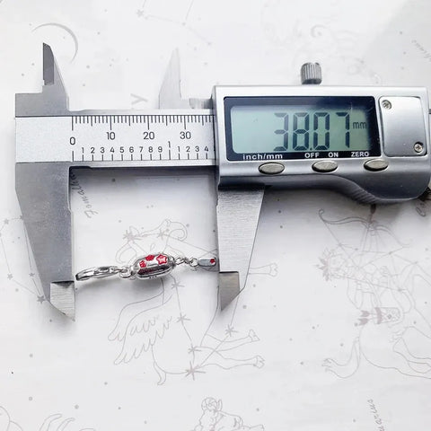 Silver bracelet with red accents being measured.