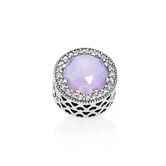 Sterling silver charm with lavender crystal center and cubic zirconia halo, with intricate side designs.