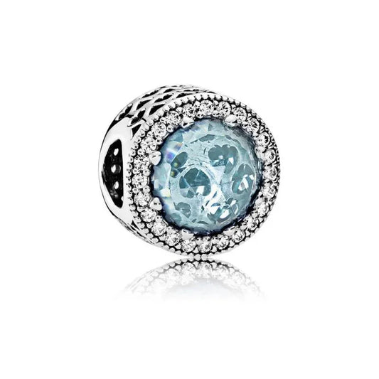 Sterling silver charm with light blue crystal center and cubic zirconia halo detailing.