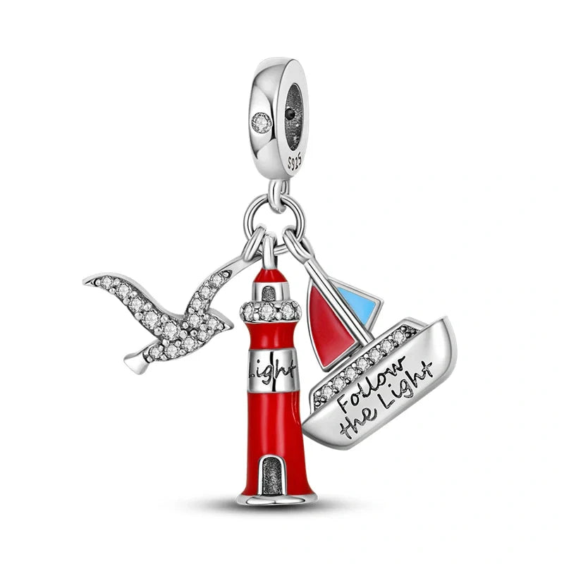 Sterling silver charm featuring a red enamel lighthouse, boat with "Follow the Light" inscription, and sparkling seagull.