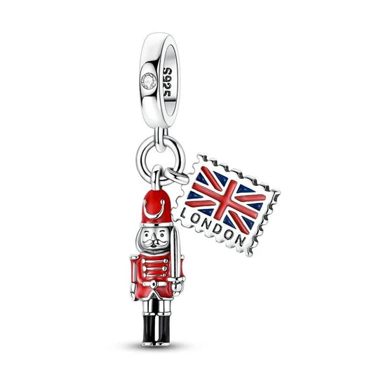 Sterling silver dangle charm featuring a red-coated royal guard soldier and a Union Jack postage stamp engraved with London, with a cubic zirconia set bail