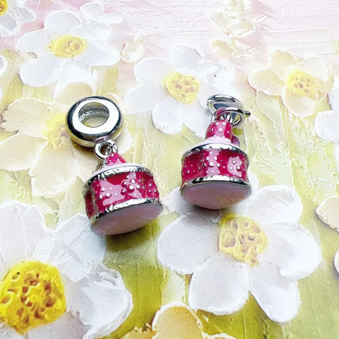 Two pink cake charm beads.