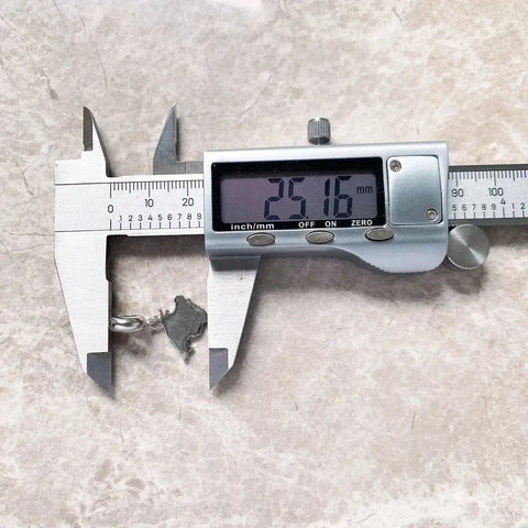 Digital caliper measuring a pendant.