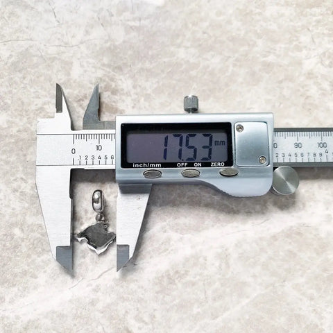Digital caliper measuring a pendant.