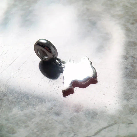 Shiny silver Rwanda-shaped charm.