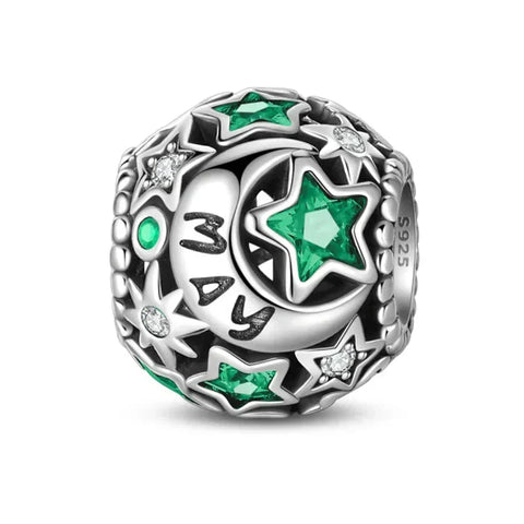 Silver charm with green and clear stones.