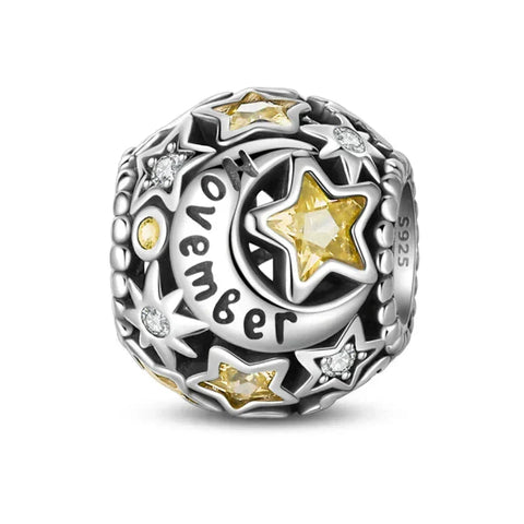 Silver charm with yellow stars and moon.
