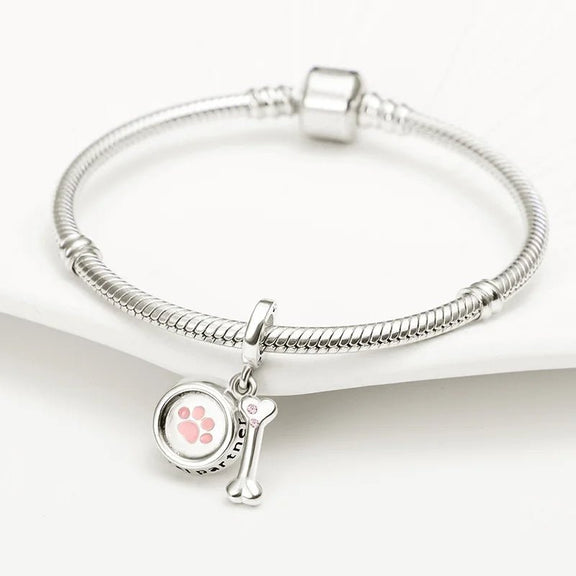 Sterling Silver Loyal Partner Dog Charm with Bone for Pandora Bracelets - Beautiful sterling silver dog charm featuring a pink paw print and bone, perfect for honoring your loyal pet.