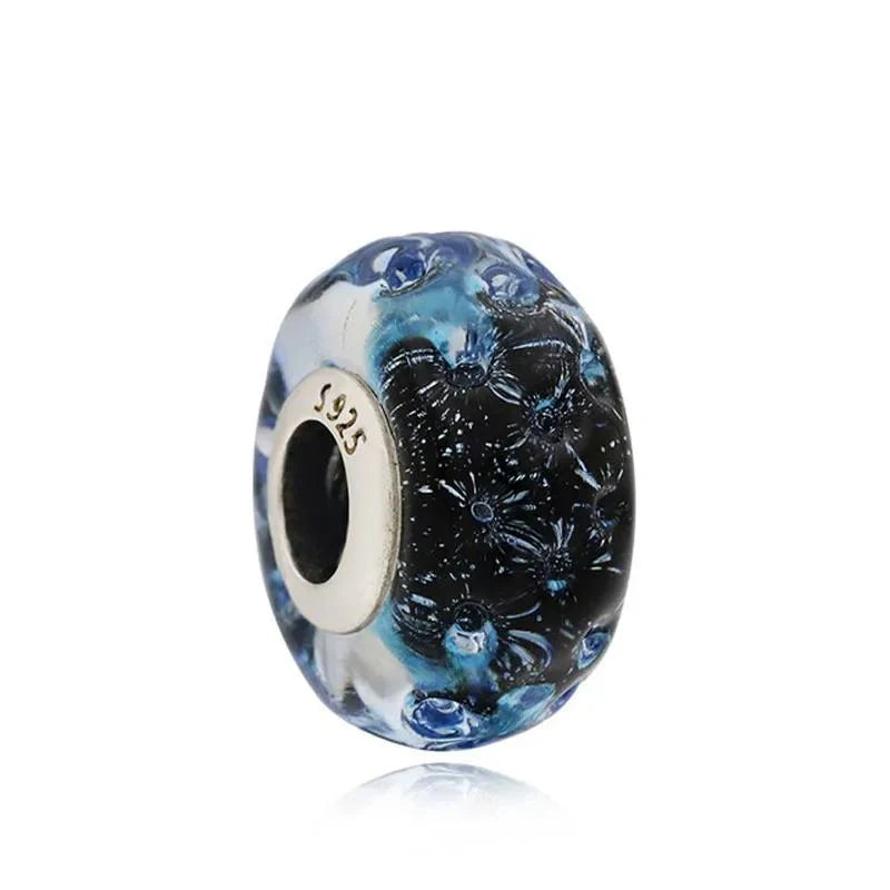 Blue floral glass charm with intricate flower patterns and a sterling silver core for a nature-inspired design.