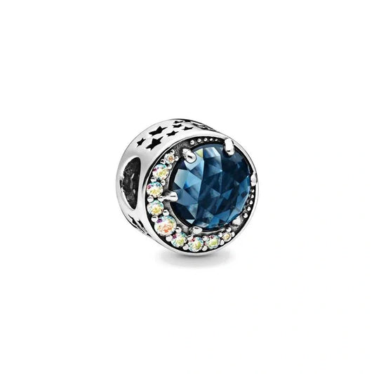 Sterling silver charm with a deep blue gemstone accented by a crescent moon of sparkling crystals.