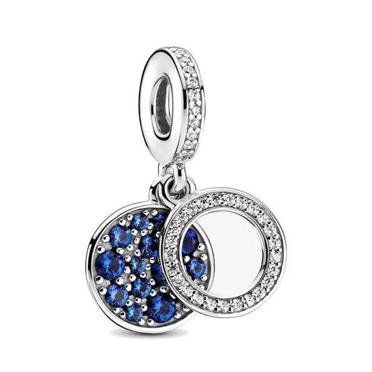 Sterling silver double circle drop charm with blue and clear crystals for an elegant and sophisticated look.