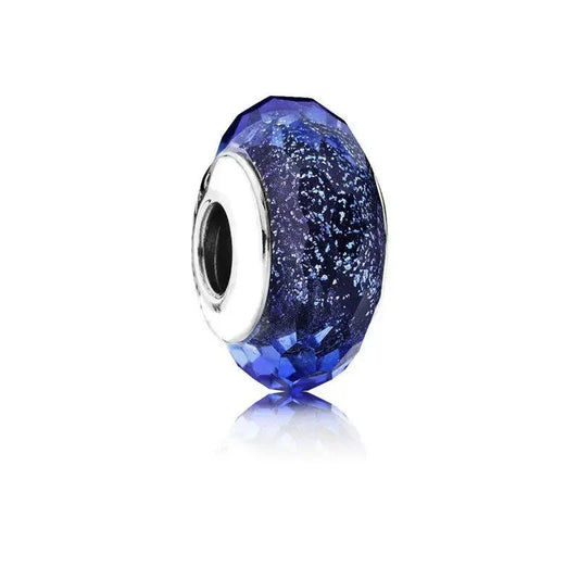 Faceted blue glass charm with a sterling silver core, creating a sparkling and colorful design.