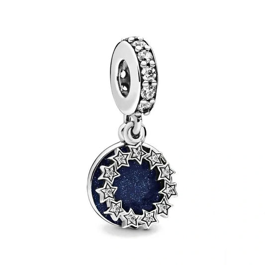 Sterling silver hanging charm with a deep blue enamel center surrounded by stars and sparkling crystals.