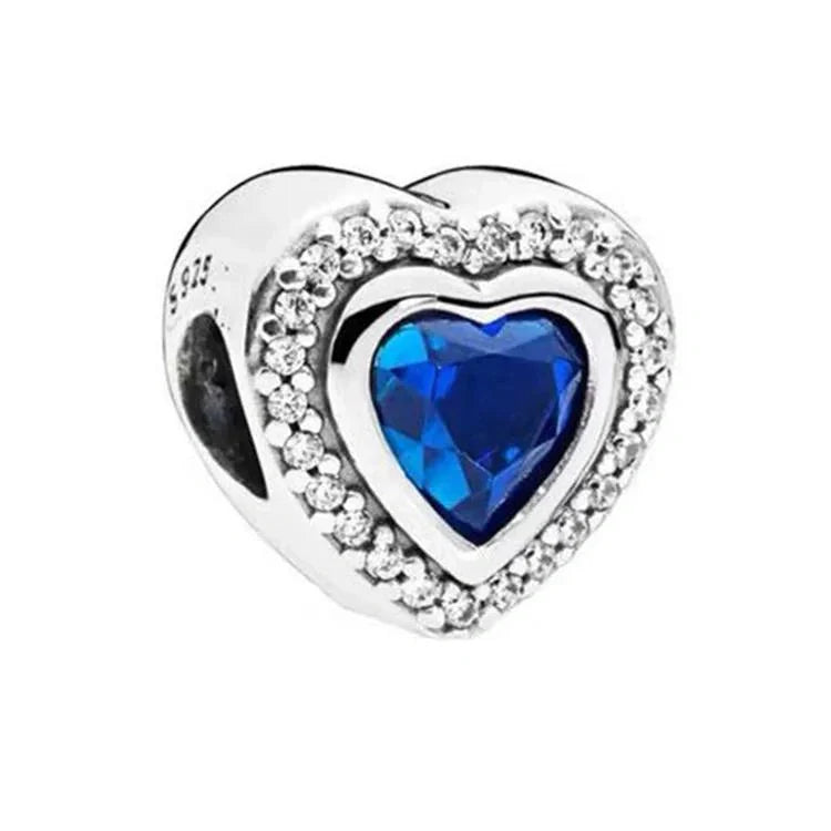 Sterling silver heart-shaped charm with a blue crystal center surrounded by a halo of clear stones for an elegant design.