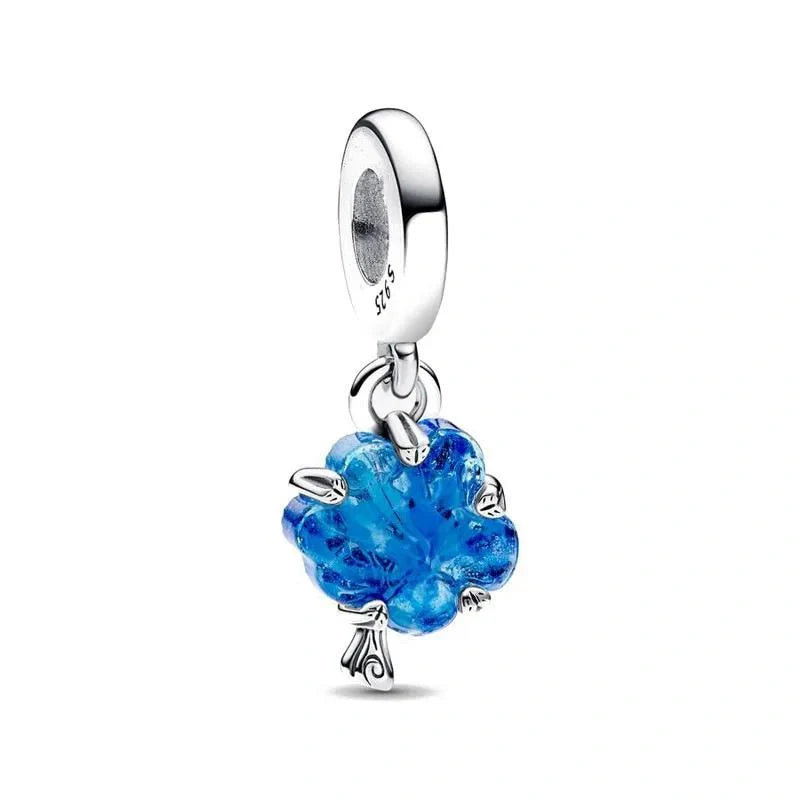 A sterling silver turtle charm with a vibrant blue crystal forming the shell, crafted with detailed legs and head for a realistic marine look.