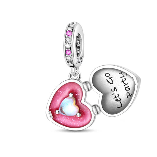 A sterling silver heart-shaped locket charm with a pink stone and "Let’s Go Party" engraved inside, perfect for celebrations.