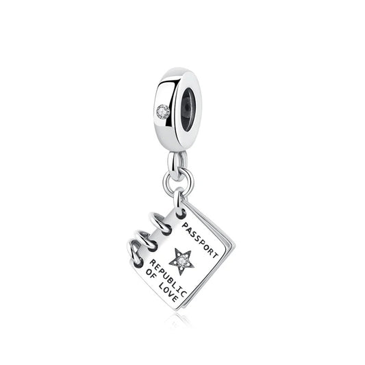 Silver dangle charm shaped like a miniature passport engraved with 'Passport Republic of Love' and a cubic zirconia star, attached to a clip-on bead bail with a CZ stone