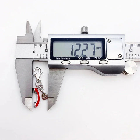 Digital caliper measuring a charm.