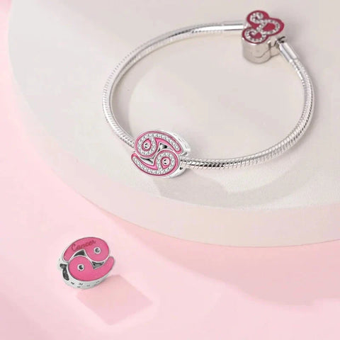 Silver charm bracelet with pink Cancer zodiac charms.