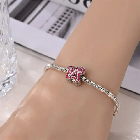 Silver charm bracelet with pink letter charm.