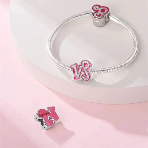 Silver charm bracelet with pink Capricorn charms.