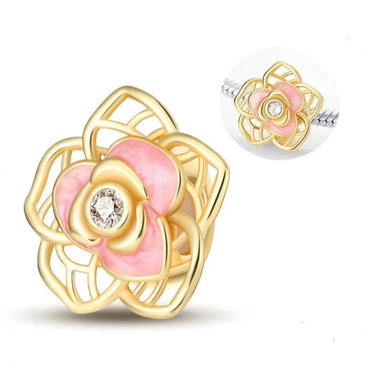 Gold and pink enamel rose flower charm with intricate details and a crystal center, ideal for floral jewelry lovers.