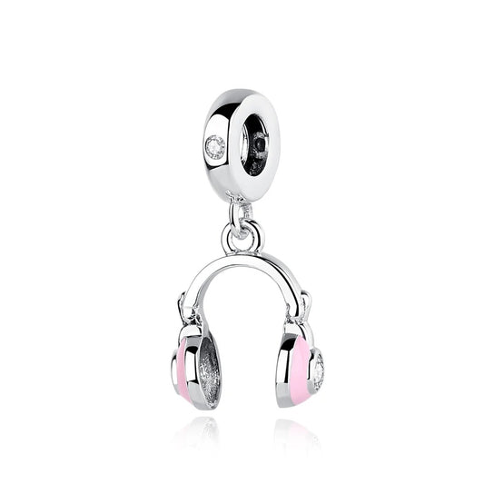 A silver-tone dangle charm shaped like over-ear headphones with pink enamel ear cups and clear cubic zirconia stones, hanging from a round clip bead charm