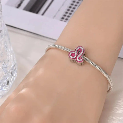 Silver charm bracelet with a pink Leo zodiac sign.