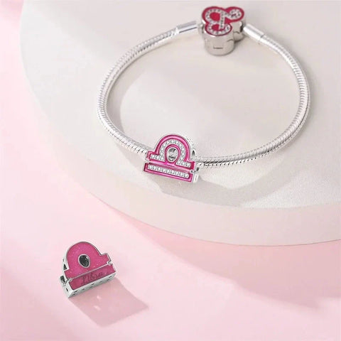 Silver bracelet with pink Libra charms.