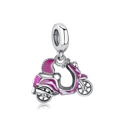A silver-tone dangle charm shaped like a retro pink and magenta enamel moped scooter with a matching helmet, suspended from a rounded clip-on bail