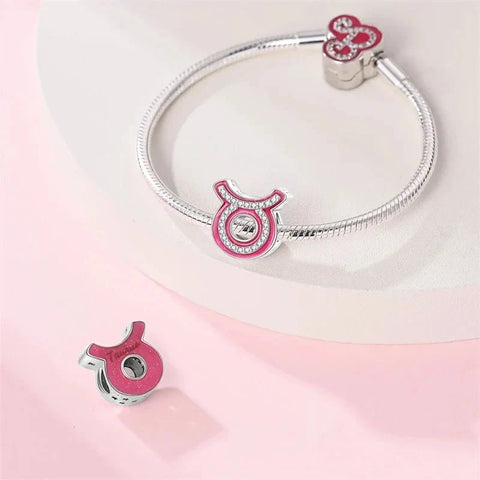 Silver charm bracelet with Taurus zodiac charms.