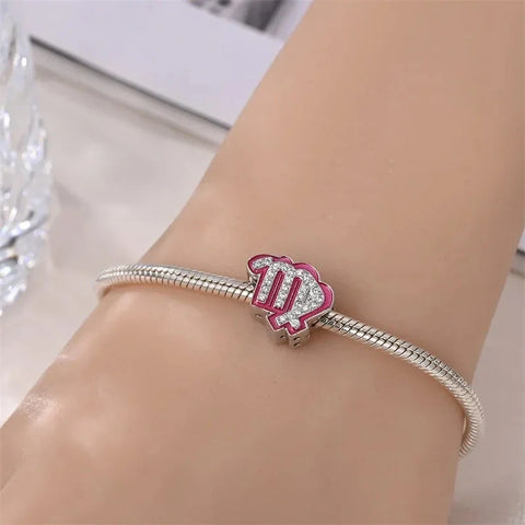 Silver charm bracelet with pink Virgo zodiac sign.