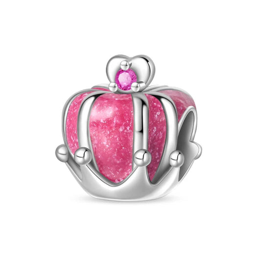 A sterling silver crown charm with pink enamel and a zirconia gem, symbolizing royalty, strength, and beauty.