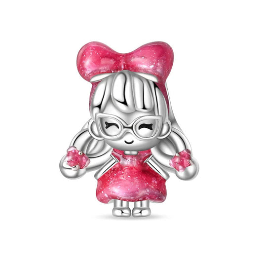 Sterling silver doll charm with a pink bow and dress, perfect for adding a playful touch to any jewelry collection.